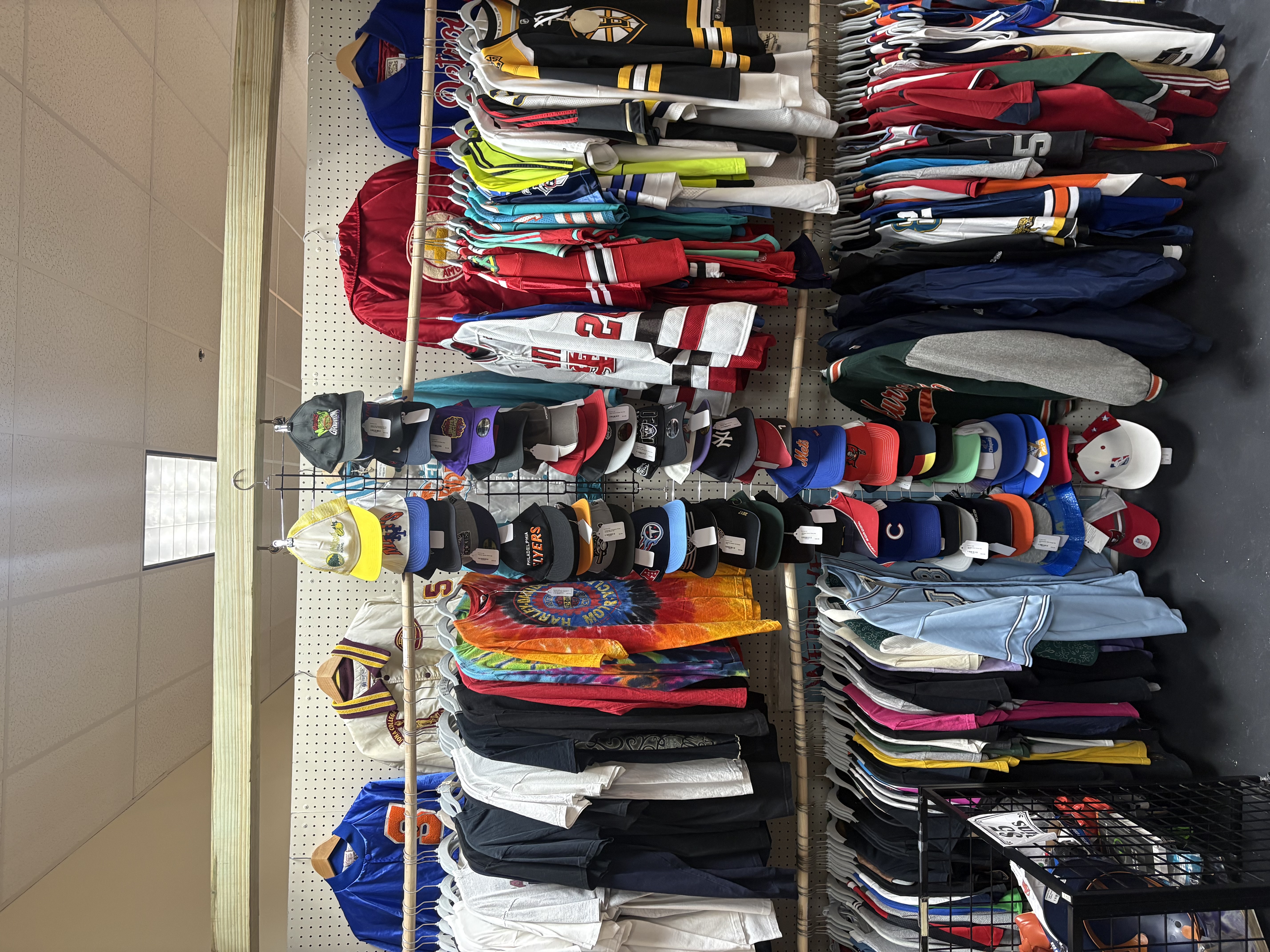 Hats, jerseys, and vintage clothing racks in the shop